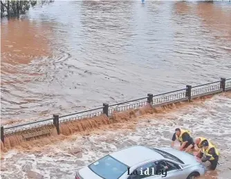  ?? ?? A flood camera captures the moment people attempt to help a stranded driver.