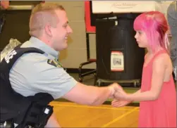  ?? ANDREA PEACOCK/The Daily Courier ?? A police officer shakes hands with a student at Quigley Elementary School after being recognized as a member of Alexa’s Team during a ceremony Wednesday.