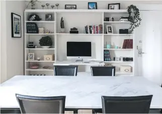  ??  ?? The dining room table features metal legs and a white Carrara marble top.