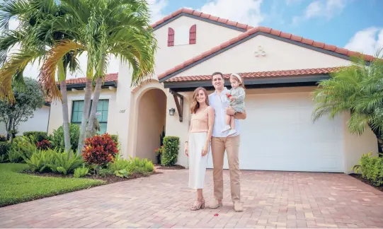  ?? KENDALL SHORT/THE NEW YORK TIMES ?? Melanie Granuzzo and Brandon Fried with daughter Amelia outside their vacation home in Florida. They’re spending part of winter in South Carolina.