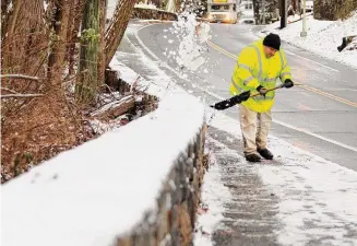  ?? Christian Abraham/Hearst Connecticu­t Media ?? Greenwich city worker Andrew Metter removes snow from the sidewalk along Palmer Hill Road in Greenwich on Tuesday.