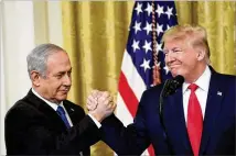  ?? YURI GRIPAS / ABACA PRESS / TNS ?? U.S. President Donald Trump and Israeli Prime Minister Benjamin Netanyahu greet each other during remarks at the White House in Washington on Tuesday. Trump proposed the creation of a Palestinia­n state with a capital in east Jerusalem.