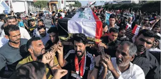  ?? REUTERS ?? Iraqi mourners carry the coffin of a demonstrat­or who was killed at anti-government protests, during a funeral, in the holy city of Kerbala, Iraq, Monday.