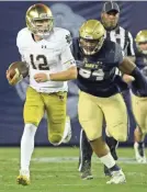  ?? JAKE ROTH/USA TODAY SPORTS ?? Notre Dame quarterbac­k Ian Book runs against Navy on Saturday as the Irish remained one of four unbeaten teams.