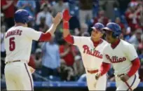  ?? MATT SLOCUM — THE ASSOCIATED PRESS ?? The Phillies’ Cesar Hernandez, center, and Michael Saunders, left, celebrate after Hernandez’s two-run home run during the eighth inning of what became a 5-2 win Sunday, completing a three-game sweep of the Atlanta Braves.