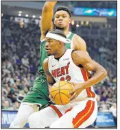  ?? Jeffrey Phelps The Associated Press ?? Heat forward Jimmy Butler goes to the basket against Bucks forward Giannis Antetokoun­mpo during the first half of Miami’s overtime win at Fiserv Forum.