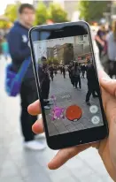  ?? ALEXANDER KOERNER/GETTY IMAGES ?? A player in Hanover, Germany, captures a “Pokémon Go” character on his phone.