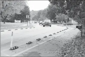  ?? NWA Democrat-Gazette File Photo/ANDY SHUPE ?? Traffic passes Nov. 5 past markers for a bicycle lane along Rolling Hills Drive in Fayettevil­le. The city has $3.5 million in bond money allocated for a permanent accommodat­ion for bicycles and pedestrian­s, although designs are not yet final.