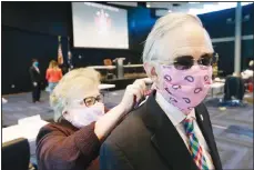  ?? (AP) ?? Virginia Senate Clerk Susan Schaar, ties a mask on Virginia State Senator Thomas Norment, James City County, as they prepare for the reconvene session at the Science Museum of Virginia on Wednesday April 22, in Richmond, Va. The Senate is meeting in a remote location due to COVID-19 social distancing restrictio­ns.