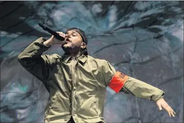  ?? Kent Nishimura Los Angeles Times ?? THE WEEKND strikes a pose during his set, in which he offered a portrait of masculinit­y in crisis, critic says.