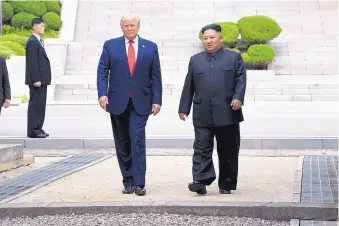  ?? SUSAN WALSH/ASSOCIATED PRESS ?? U.S. President Donald Trump and North Korean leader Kim Jong Un walk on the North Korean side of the border in the Demilitari­zed Zone on Sunday.