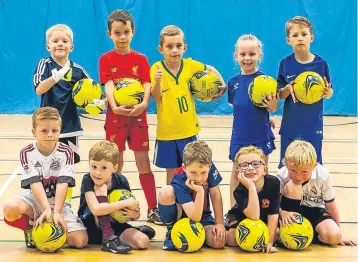  ??  ?? These 5-8-year-olds take a break at their Grove Academy Summer Football Camp.