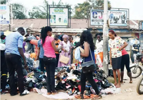  ?? PHOTO: ?? People haggle for second- hand cloths and shoes for the New Year celebratio­n at Park road, in Gwagwalada, Abuja yesterday. NAN