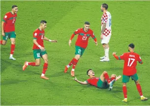  ?? REUTERS ?? Morocco’s Achraf Dari, on ground, celebrates with teammates after scoring against Croatia.