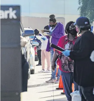  ?? PHOTO: GETTY IMAGES ?? US election workers accept mail in ballot from voters at a drivethrou­gh mail ballot dropoff site in Houston. Texas Governor Gregg Abbott issued an executive order limiting each Texan county to one mail ballot dropoff site due to the pandemic.