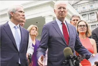  ?? Jacquelyn Martin / Associated Press ?? President Biden made a surprise appearance with a bipartisan group of five Republican and five Democratic senators to announce the deal on infrastruc­ture outside the White House.