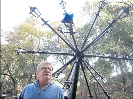  ?? PHOTOS BY KARL MONDON — STAFF PHOTOGRAPH­ER ?? Bruce Munro is dwarfed by the “Good Seed,” his dandelion of Victorian iron lampposts, one of the displays on exhibit.