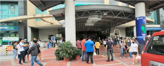  ?? PHOTOGRAPH BY BOB DUNGO JR. FOR THE DAILY TRIBUNE @tribunephl_bob ?? MALLGOERS linger outside Robinson’s Manila in Ermita as they wait for the malls opening. The mall’s management has adjusted their operations to 11 a.m. instead of the previous 10 a.m. opening.