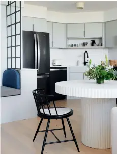  ??  ?? BELOW: A raw concrete pedestal table fits neatly in the corner of the kitchen. Table, CB2; chair, Wayfair Canada; ceiling fixure, Huey Lightshop.