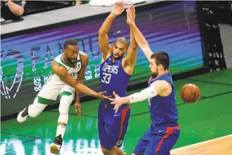  ?? Elise Amendola / Associated Press ?? Boston guard Kemba Walker (left) passes the ball between Clippers forward Nicolas Batum (33) and center Ivica Zubac in the first quarter of their game in Boston.