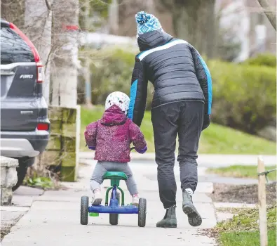  ?? PETER J THOMPSON / NATIONAL POST ?? A mother guides her child on a bicycle along a Toronto street Thursday as the COVID-19 pandemic continues.