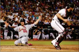  ?? ASSOCIATED PRESS ?? ST. LOUIS CARDINALS’ STEPHEN PISCOTTY (55) SCORES a run as Arizona Diamondbac­ks’ Jeff Mathis (right) waits for a late throw during the fourth inning of a game between the Arizona Diamondbac­ks and the St. Louis Cardinals on Wednesday in Phoenix.