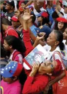  ?? ARIANA CUBILLOS, THE ASSOCIATED PRESS ?? A supporter of Nicolas Maduro holds a photo of Hugo Chávez during a rally in Caracas Thursday.