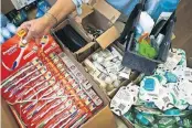  ??  ?? Betances adds toothbrush­es to the hygiene kits she’s packing for students in the Rising Youth program.