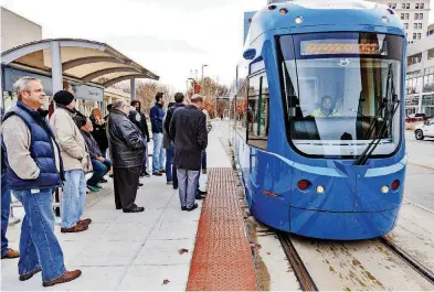  ?? [PHOTO BY CHRIS LANDSBERGE­R, THE OKLAHOMAN] ?? People wait to board the streetcar at the Century Center stop for a free ride during the grand opening of the Oklahoma City streetcar system
