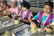  ?? GALIH ADI/JAWA POS ?? ILMU BARU: Nur Kholifah dan Juhar Efendi (kanan) membuat burger di salah satu restoran Jalan Manyar Kertoarjo kemarin.