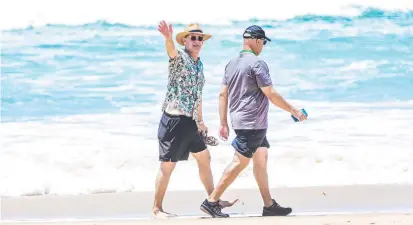  ??  ?? PRE-COVID DELIGHT: Tom Hanks enjoys a stroll along the beach at Broadbeach on the Gold Coast