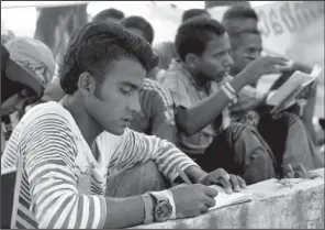  ?? AP/ TATAN SYUFLANA ?? Rohingya men learn a language at a temporary shelter in Kuala Langsa, Aceh province, Indonesia,
on Sunday.