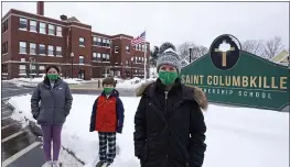  ?? CHARLES KRUPA — THE ASSOCIATED PRESS ?? Head of School Jennifer Kowieski, right, is seen Friday with students Madeline Perry, of Brookline, Mass., left, and Landon Freytag, of Newton, Mass., center, outside the Saint Columbkill­e Partnershi­p School, a Catholic school, in the Brighton neighborho­od of Boston. The families of both students decided to switch to the school, avoiding the challenges of remote learning at many public schools.