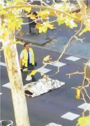  ?? — Gambar Reuters ?? MALANG: Mayat mangsa ditutupi kain terbaring di atas jalan raya selepas sebuah van merempuh pejalan kaki berhampira­n lebuh Las Ramblas di tengah Barcelona, Sepanyol kelmarin.