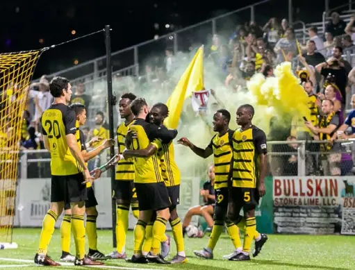  ?? Chris Cowger/Pittsburgh Riverhound­s ?? Kenardo Forbes is embraced by teammates following his goal in the club’s 3-0 win over Indy Eleven on Sept. 28 at Highmark Stadium.
