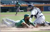  ?? DUANE BURLESON — THE ASSOCIATED PRESS ?? The A’s Elvis Andrus beats the tag from Tigers catcher Eric Haase (13) to score from first base on a double by Starling Marte on Thursday in Detroit.