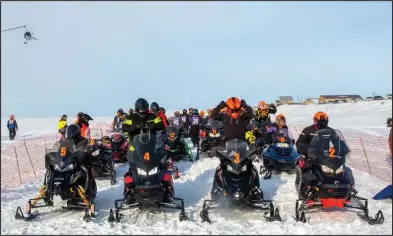  ?? Photos by James Mason ?? READY TO RACE (top)— Riders are ready for the Nome-Golovin snowmachin­e race to begin on Saturday. CHECKERED FLAG (right)– Mike Morgan is the first across the finish line.