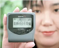  ??  ?? A Nippon Iridium employee displays a pager of Iridium satellites telephone service, made by Japan’s electronic­s giant Kyocera at the company’s head office in Tokyo. — AFP photo