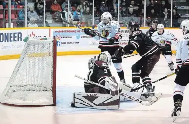  ?? GREG COWAN OWEN SOUND SUN TIMES ?? Aidan Dudas struggles to control a chest-high Kevin Hancock pass that was deflected by the Peterborou­gh Petes 16-year-old goaltender Tye Austin. The Petes and Attack met in Owen Sound at the Harry Lumley Bayshore Community Centre on Saturday night.