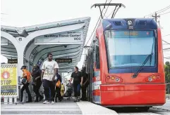  ?? Mark Mulligan / Staff photograph­er ?? Riders disembark a Metro Red Line light rail train at the HCC Northline Commons station on Monday. Metro discussed extending the Red Line at least to Tidwell Road, and possibly up to Bush airport.