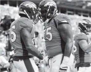  ?? Dustin Bradford, Getty Images ?? Offensive tackle Menelik Watson, right, celebrates with tight end Virgil Green after Green’s touchdown last weekend.