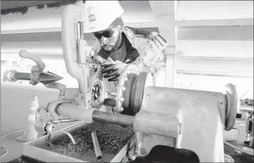  ?? NIKKI BOERTMAN/THE COMMERCIAL APPEAL ?? Electricia­n apprentice Mike Nash, of A-1 Electric, threads pipe while working at the Crosstown Concourse parking garage.