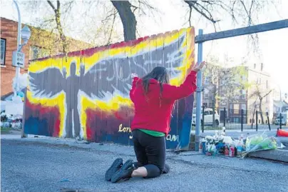  ?? E. JASON WAMBSGANS/CHICAGO TRIBUNE ?? A mother from Cicero brought her daughters to pray Friday at a memorial in the alley where Adam Toledo was fatally shot by police in the Little Village neighborho­od. Artist Pablo Serrano painted the mural.