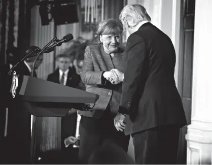  ?? Associated Press ?? n President Donald Trump shakes hands with German Chancellor Angela Merkel on Friday following their news conference in the East Room of the White House.