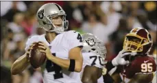  ??  ?? Oakland Raiders quarterbac­k Derek Carr looks for an opening to pass during the first half of an NFL football game against the Washington Redskins in Landover, Md., on Sunday. AP PHOTO/MARK TENALLY