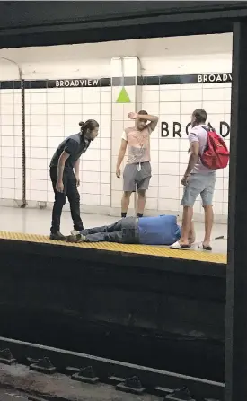 ??  ?? Three men look on after rescuing a blind man who had fallen onto the subway tracks at Broadview Station in Toronto.