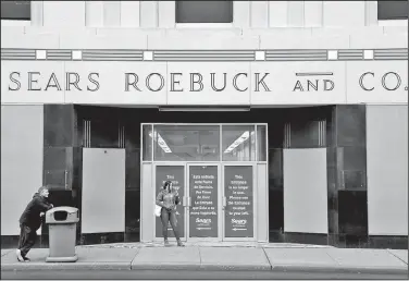  ?? AP/SETH WENIG ?? People stand outside a Sears department store Monday in Hackensack, N.J. Sears filed for Chapter 11 bankruptcy protection Monday, buckling under its massive debt load and staggering losses.