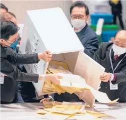  ?? ANTHONY KWAN/GETTY ?? Officials empty a ballot box following a pro-Beijing legislativ­e election Sunday in Hong Kong. Voting results are expected to be finalized Monday.