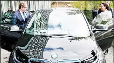  ?? (AP) ?? German Transporta­tion Minister Alexander Dobrindt (left), and his staff members get on the minister’s e-car after a press conference in Berlin, Germany, on April 27. Germany plans to subsidize electric cars in a bid to help the country’s auto industry...