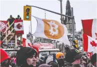  ?? STEPHANIE KEITH / BLOOMBERG FILES ?? A protester holds a Bitcoin flag at a demonstrat­ion
near Parliament Hill in Ottawa in February.